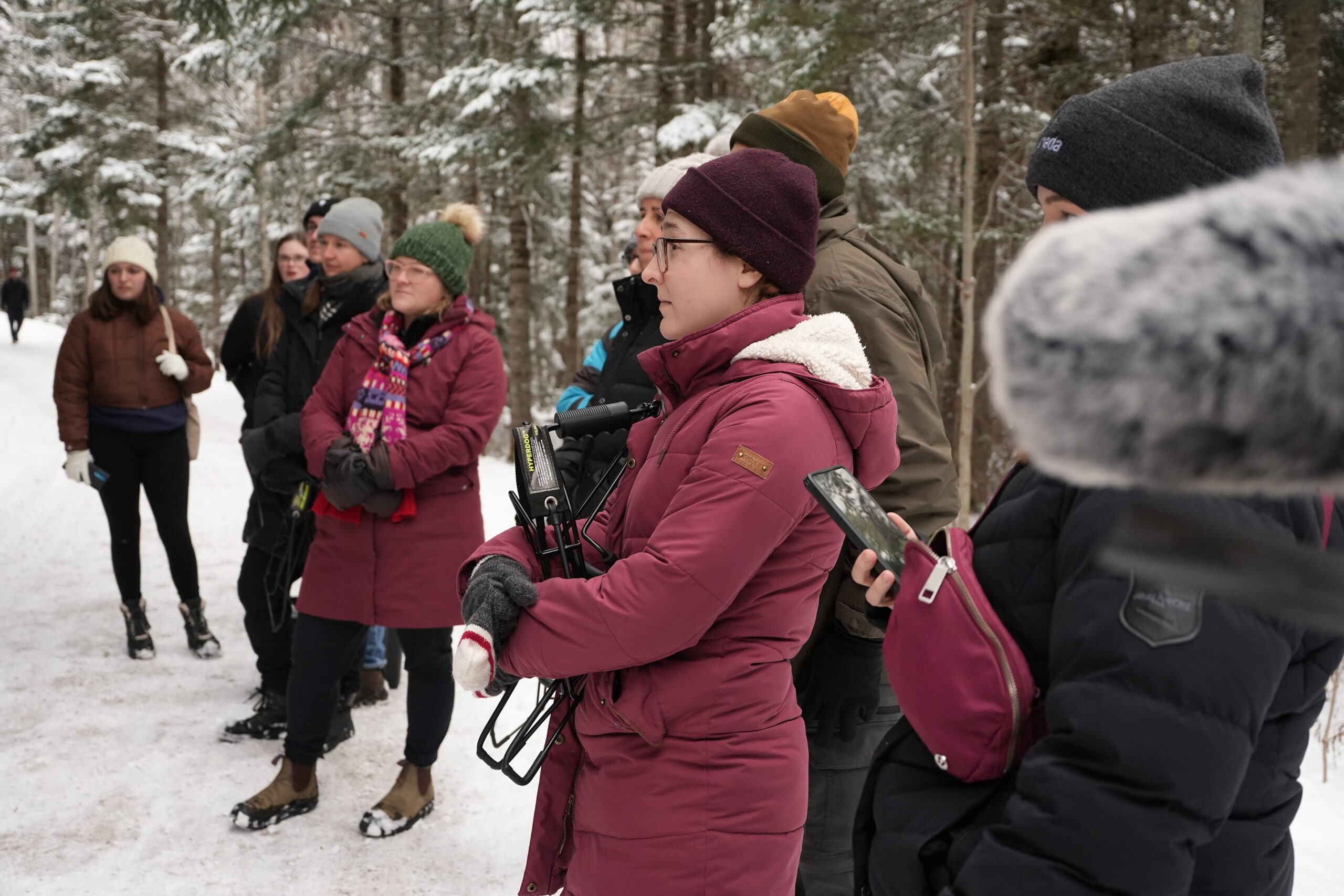 People in winter jackets standing in a forest